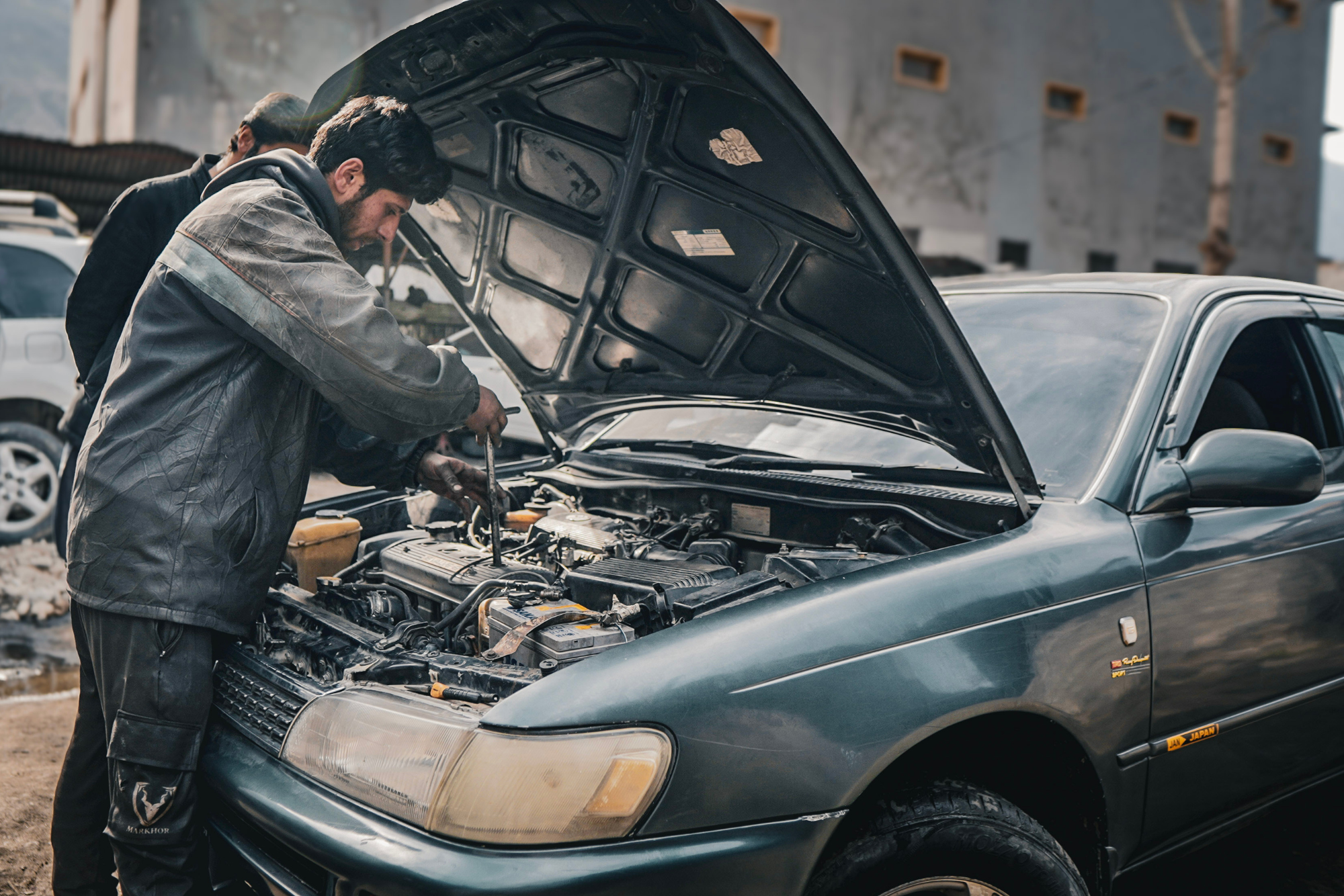 mechanic working on a car outside in shunshine